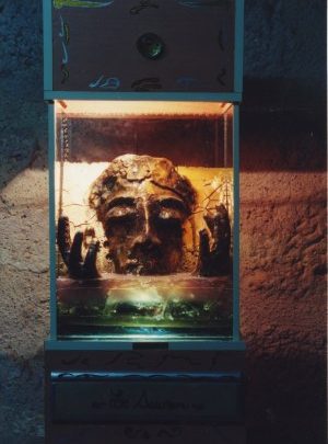 Sculpture du visage du Christ levant ses deux mains